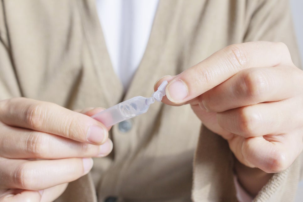 Hands twisting open a preservative-free single-use artificial tear vial