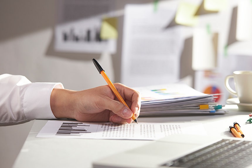 Pharmacist reviewing printed research papers on dry eye at a desk