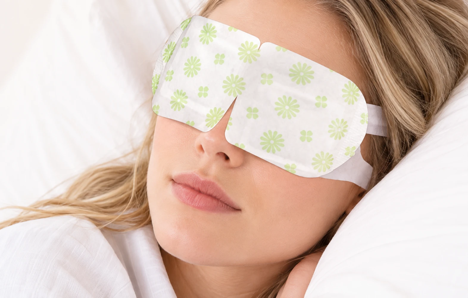 Woman resting with a warm compress eye mask to melt clogged eyelid oil glands